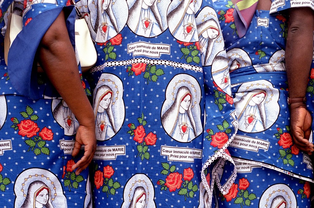 Worshippers to Lourdes from the Ivory Coast wearing dresses patterned with an image of the Virgin.  